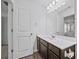 Well-lit bathroom featuring a vanity with dark cabinets and a large mirror at 2056 Wildflower Way, Conyers, GA 30012
