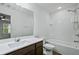 Bathroom featuring a tub and shower, white tile surround, large mirror, and modern vanity at 2056 Wildflower Way, Conyers, GA 30012