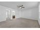 Bright bedroom with neutral carpet, ceiling fan, and doors to ensuite bathroom and closet at 2056 Wildflower Way, Conyers, GA 30012