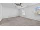 Spacious bedroom features neutral carpet, ceiling fan, and multiple windows for ample natural light at 2056 Wildflower Way, Conyers, GA 30012