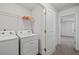 A laundry room featuring a washer and dryer, along with a wire shelving and white walls at 2056 Wildflower Way, Conyers, GA 30012