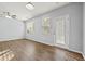 Bright living room featuring wood floors, ceiling fan, and large windows with a glass door at 2056 Wildflower Way, Conyers, GA 30012