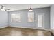 Living room featuring wood floors, neutral walls, large windows, and modern lighting fixtures at 2056 Wildflower Way, Conyers, GA 30012