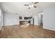 Open-concept living room featuring wood floors that connect to the kitchen and large windows at 2056 Wildflower Way, Conyers, GA 30012