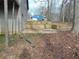 View of the backyard featuring a multi-tiered retaining wall and a glimpse of a blue house in the distance at 3321 Border Dr, Stone Mountain, GA 30087
