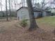 Back of home featuring a gray exterior, small deck, and wooded lot at 3321 Border Dr, Stone Mountain, GA 30087