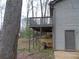 Back of home featuring a raised wooden deck and a wooded yard with sparse greenery at 3321 Border Dr, Stone Mountain, GA 30087