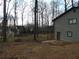 Backyard view featuring a raised wooden deck, a wooded area, and gray siding at 3321 Border Dr, Stone Mountain, GA 30087