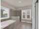 Bright bathroom features a soaking tub, tiled shower with glass surround, and large windows at 3000 Smyrna Grove Dr, Smyrna, GA 30082