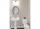 Charming half-bath featuring a pedestal sink, toilet, and decorative mirror, with dark wood floors at 3000 Smyrna Grove Dr, Smyrna, GA 30082