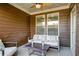 Inviting outdoor seating area on the porch, featuring modern furniture, neutral textures, and a ceiling fan at 3000 Smyrna Grove Dr, Smyrna, GA 30082