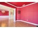 Formal dining room with hardwood floors and red walls at 1070 Blackwood Ct, Johns Creek, GA 30024