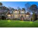 Charming two-story home with a landscaped yard, wooden porch and stairs, and black railings at 3051 Maple Ln, Alpharetta, GA 30009