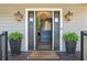 Welcoming entry with dark gray door, lanterns and potted plants at 3051 Maple Ln, Alpharetta, GA 30009