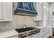 A kitchen featuring a stainless steel range, white cabinets, and a blue and gold range hood at 3051 Maple Ln, Alpharetta, GA 30009