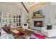 Living room featuring a stone fireplace, built-in shelving, and hardwood floors at 3051 Maple Ln, Alpharetta, GA 30009