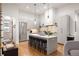 Bright open kitchen with stainless steel appliances, pendant lighting and bar stool seating at 122 Gainey Ln, Chattahoochee Hills, GA 30268