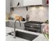 Updated kitchen featuring white subway tile backsplash, modern gray cabinets, and stainless steel appliances at 122 Gainey Ln, Chattahoochee Hills, GA 30268