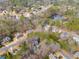 Aerial view of a neighborhood with a home surrounded by mature trees and community amenities at 785 Charleston Dr, Roswell, GA 30075