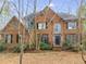 Charming brick two-story home with mature landscaping, arched window, and dark shutters at 785 Charleston Dr, Roswell, GA 30075