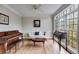 Cozy living room featuring hardwood floors, piano, and large windows offering natural light at 785 Charleston Dr, Roswell, GA 30075