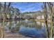 Picturesque pond view with a fountain, surrounded by tall trees and apartment buildings against a blue sky at 1379 Keys Lake Ne Dr, Brookhaven, GA 30319