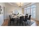 Elegant dining room featuring modern chandelier, shuttered windows, wainscoting, and large dining set at 3184 Islesworth Trce, Duluth, GA 30097
