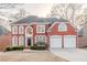 Stately brick home featuring a two-car garage, arched windows, and a meticulously landscaped front yard at 3184 Islesworth Trce, Duluth, GA 30097