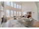 Sun-drenched living room with fireplace, soaring windows, hardwood floors, and neutral furniture at 3184 Islesworth Trce, Duluth, GA 30097
