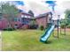 Green backyard with playground and home view at 619 Champions Dr, Mcdonough, GA 30253