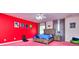 Red and pink bedroom with a bed, dresser, and playful decor at 619 Champions Dr, Mcdonough, GA 30253