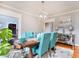 Elegant dining room featuring a wooden table, teal chairs, and a modern chandelier at 619 Champions Dr, Mcdonough, GA 30253