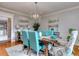 Bright dining room with a rustic wooden table and teal chairs at 619 Champions Dr, Mcdonough, GA 30253