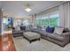 Spacious living room featuring a large sectional sofa, ottoman, and hardwood floors at 619 Champions Dr, Mcdonough, GA 30253