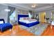 Elegant main bedroom showcasing a blue velvet bed, hardwood floors, and large windows at 619 Champions Dr, Mcdonough, GA 30253