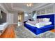 Luxurious main bedroom with a plush blue velvet bed and hardwood floors at 619 Champions Dr, Mcdonough, GA 30253