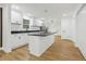 Bright kitchen featuring white cabinets, black countertops, stainless steel appliances, a kitchen island, and wood flooring at 1111 Osborne Sw St, Atlanta, GA 30310