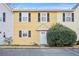 Cute yellow two-story townhouse with white door and landscaping at 2858 Spring Villa Se Ln, Smyrna, GA 30080