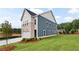 Striking two-story home showcasing blue siding, stone accents, a two-car garage, and manicured landscaping at 5756 Tillman Way, Powder Springs, GA 30127