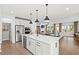Spacious kitchen with stainless steel appliances and a large island overlooking the living room at 5756 Tillman Way, Powder Springs, GA 30127