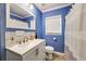Stylish bathroom features a new vanity, framed mirror, and shower with modern fixtures and blue accent wall at 1770 Rockland Se Dr, Atlanta, GA 30316