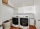 Functional laundry room with washer, dryer, wood flooring, built-in shelves, and natural light from the window at 1770 Rockland Se Dr, Atlanta, GA 30316