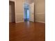 Neutral bedroom with light walls, modern flooring, and an open doorway to another room at 220 Canterbury Ln, Lawrenceville, GA 30046