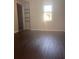Bedroom featuring hardwood floors, natural light, built in shelves and a view of the outside at 220 Canterbury Ln, Lawrenceville, GA 30046