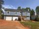 Charming two-story home featuring blue siding, a red front door, two-car garage, and a well-maintained lawn at 220 Canterbury Ln, Lawrenceville, GA 30046