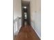Long hallway with wood floor and a view of the doorway at the end at 220 Canterbury Ln, Lawrenceville, GA 30046