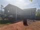 View of the raised rear exterior of the home with blue siding and covered area underneath at 220 Canterbury Ln, Lawrenceville, GA 30046