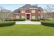 Elegant brick home boasts an arched entryway, pristine lawn, and manicured landscaping at 2280 Wilshire Dr, Grayson, GA 30017