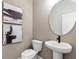 Elegant powder room with a pedestal sink, modern fixtures, and decorative wall art at 5270 Birch Valley Rd, Cumming, GA 30028