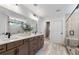 Bright bathroom with a double vanity, tiled floors, glass-enclosed shower with bench, and a view to the toilet room at 5270 Birch Valley Rd, Cumming, GA 30028